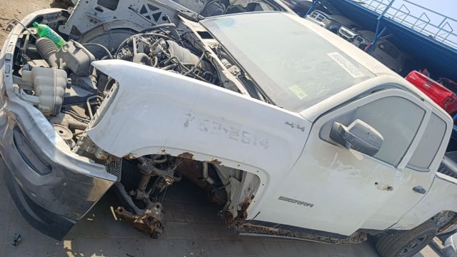 White GMC Sierra 4x4 pickup for parts, hood off showing V8 engine, fender and front bumper, Sharjah market