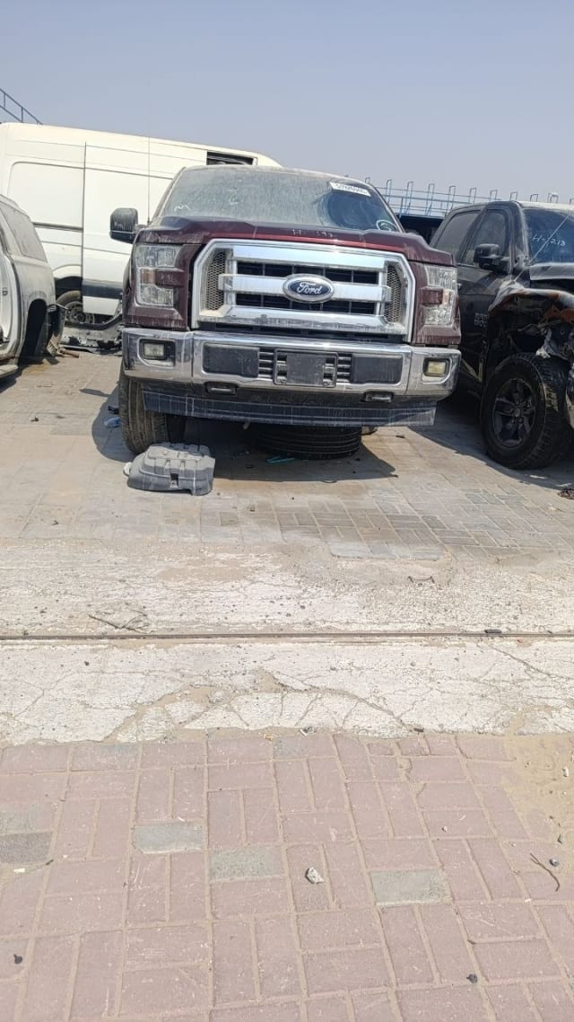 Maroon Ford F-150 pickup for parts, front view with chrome grille, headlights and bumper, Sharjah market