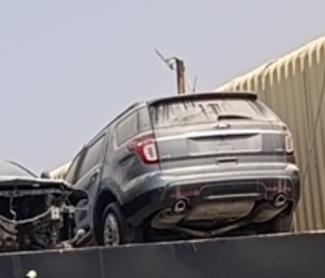 Dusty dark grey Ford Explorer SUV rear view — tailgate, taillights and rear bumper, Sharjah market