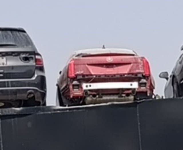 Red Cadillac XTS for parts, rear view with trunk lid, taillights and bare bumper bar, Sharjah market