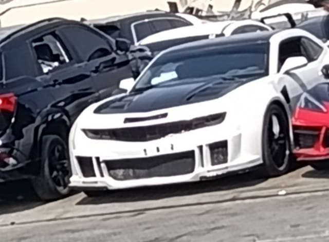 White Chevrolet Camaro coupe with black vented hood and custom front bumper, Sharjah market
