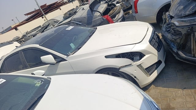 White Cadillac CTS for parts — hood, grille, front bumper and fender, missing headlight, Sharjah market
