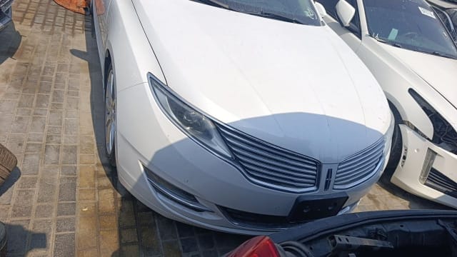 White Lincoln MKZ sedan front, with hood, chrome grille, headlights and bumper visible, Sharjah market