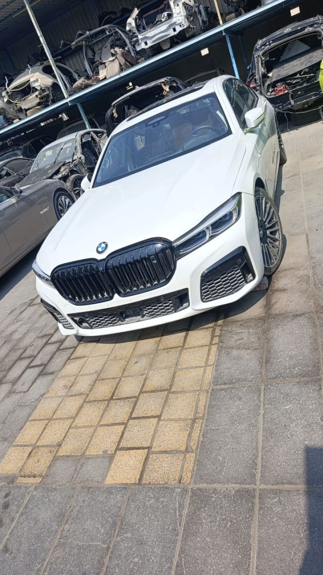 White BMW 7-Series sedan for parts — kidney grille, front bumper, LED headlights and alloy wheels, Sharjah market