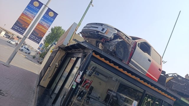 Ford F-150 pickup halfcut on shop roof — grille, headlights, red cab and doors, Sharjah market