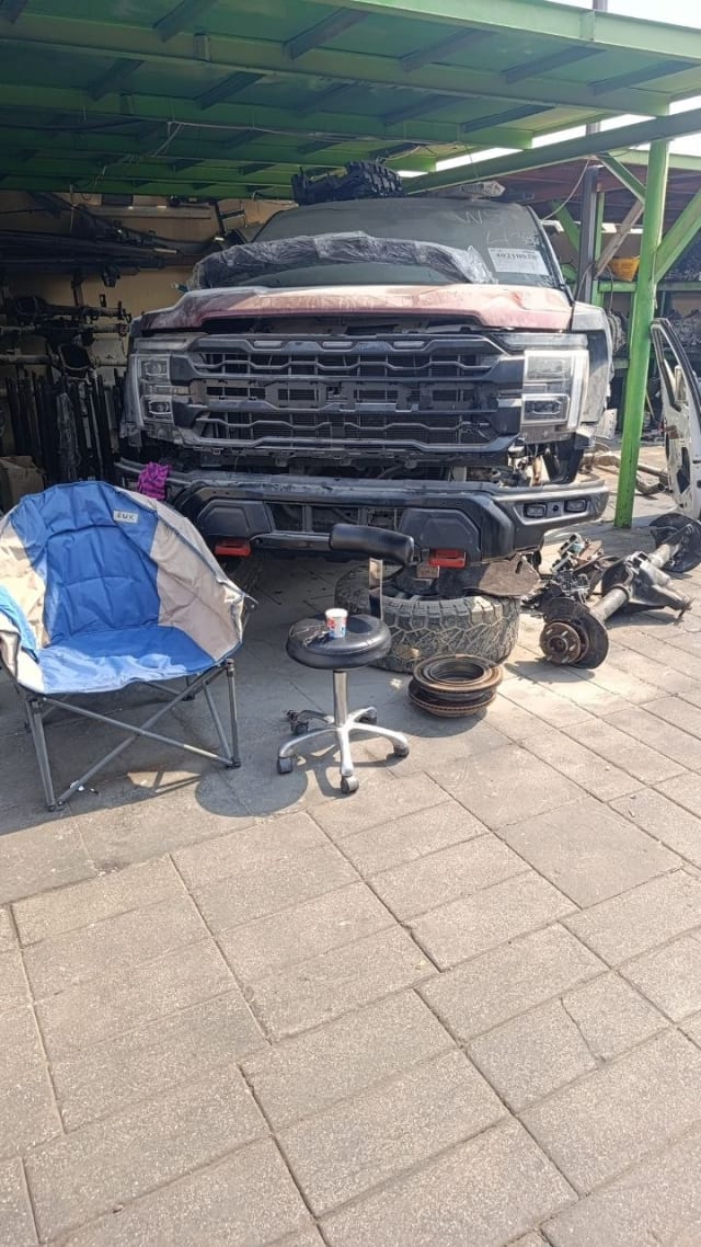 Dark red Ford F-150 for parts — grille, headlights, front bumper and removed axle, Sharjah market