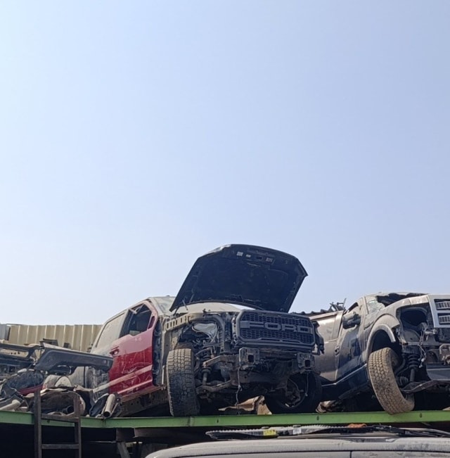 Ford F-150 Raptor halfcut with hood open and FORD grille, exposed engine bay on a rack, Sharjah market