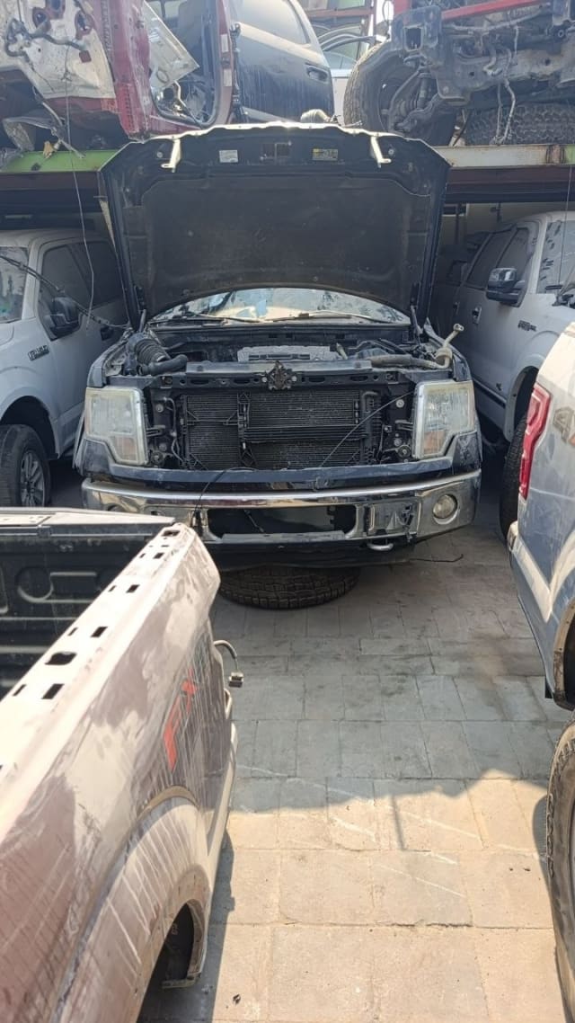 Dark blue Ford F150 for parts, hood open: headlights, chrome bumper and radiator, Sharjah market