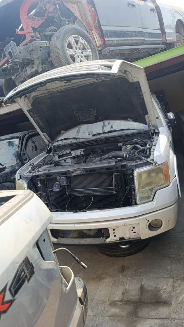 White Ford F150 halfcut with hood open — engine bay, radiator support, headlight and front bumper, Sharjah market