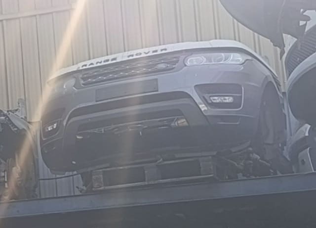 Silver Range Rover Sport front halfcut with hood, grille, headlight and bumper on a pallet, Sharjah market