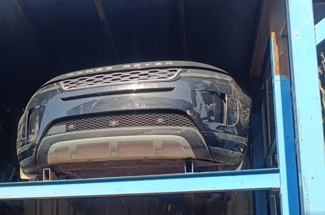 Black Range Rover Evoque front end: bumper, grille, headlights and skid plate on a rack, Sharjah market