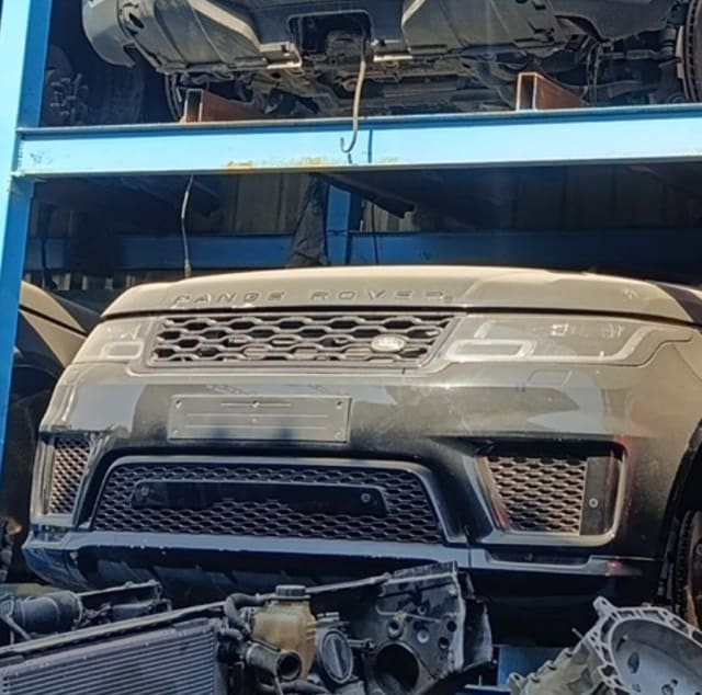 Dark grey Range Rover Sport halfcut front — hood, grille, headlights and bumper on rack, Sharjah market