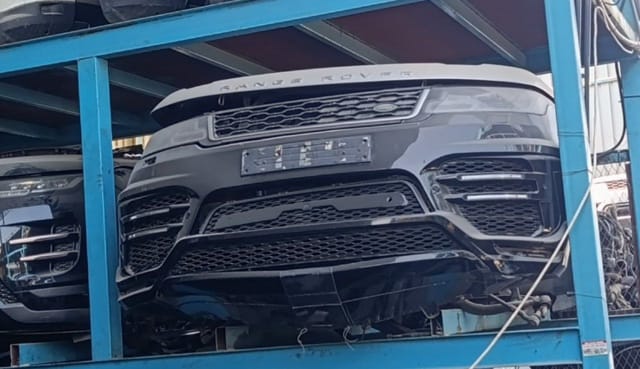 Black Range Rover Sport front halfcut with hood, grille, headlights and bumper on a rack, Sharjah market