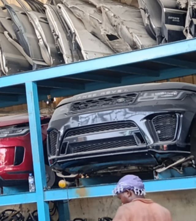 Dark grey Range Rover Sport front halfcut on a rack — bumper, grille, headlight, Sharjah market