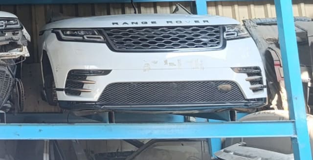 White Range Rover Velar front halfcut — hood, grille, LED headlights and bumper on rack, Sharjah market