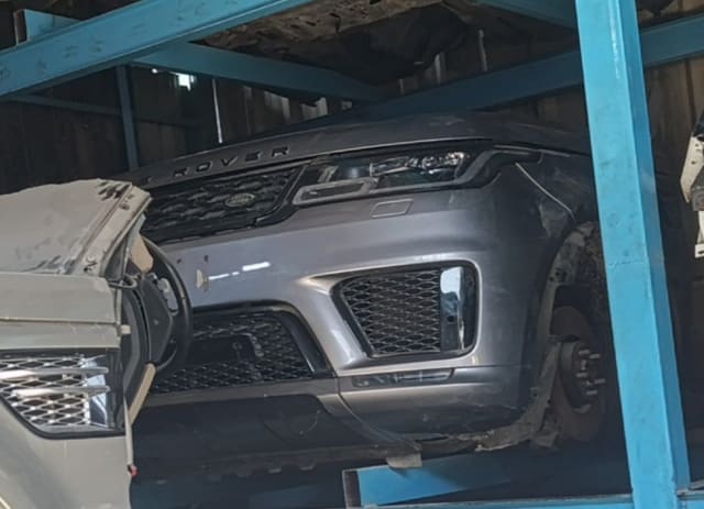 Grey Range Rover Sport halfcut front: bumper, grille, headlight and hood on a rack, Sharjah market