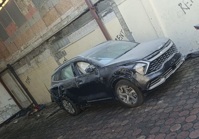 Dark grey Kia Sportage SUV for parts — front grille, headlights, hood and damaged driver side, Sharjah market