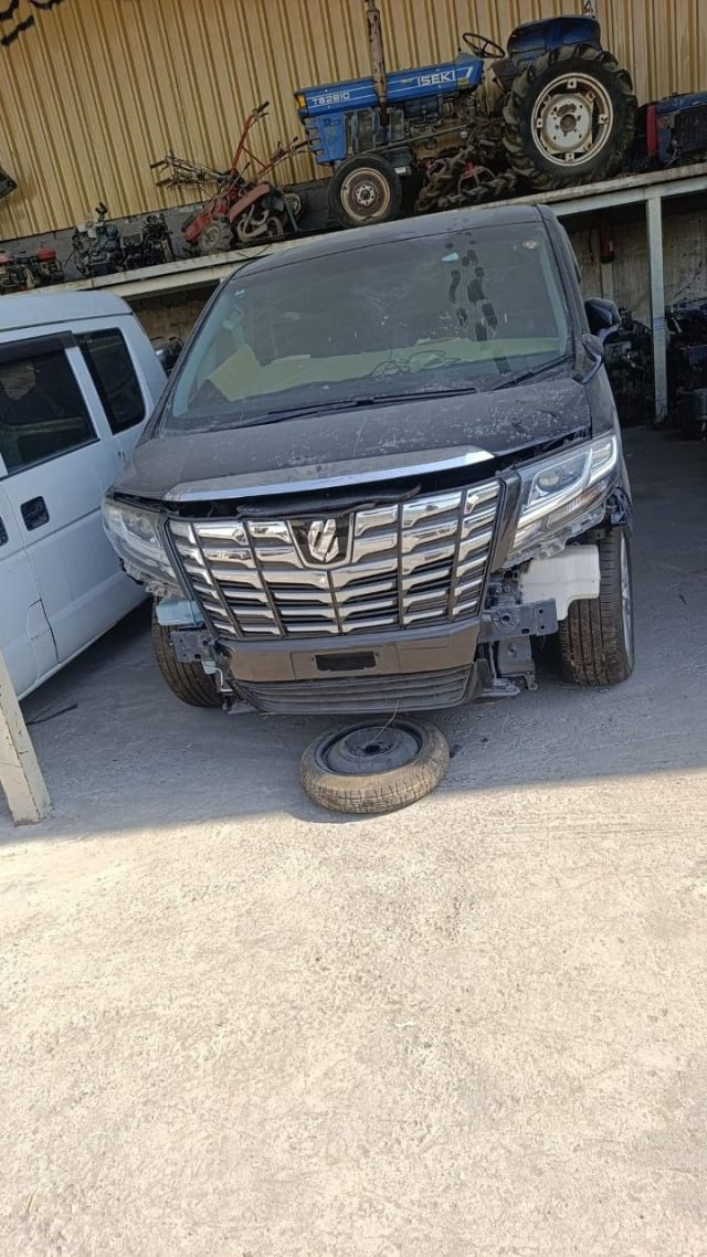 Black Toyota Alphard minivan for parts — chrome grille, headlights, hood, bumper removed, Sharjah market