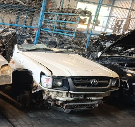 White Toyota Hilux pickup front halfcut with hood, grille, headlights and fenders, Sharjah market