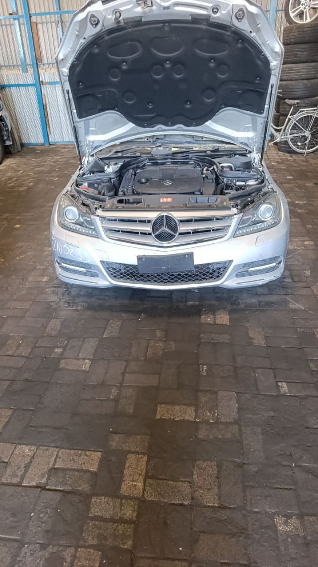 Silver Mercedes-Benz C-Class front halfcut, hood open, engine, grille, headlights and bumper, Sharjah market