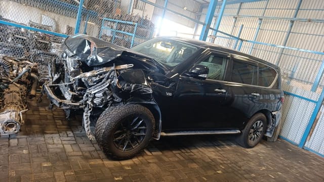 Black Nissan Patrol V8 SUV for parts — crushed hood and front, intact doors and wheels, Sharjah market