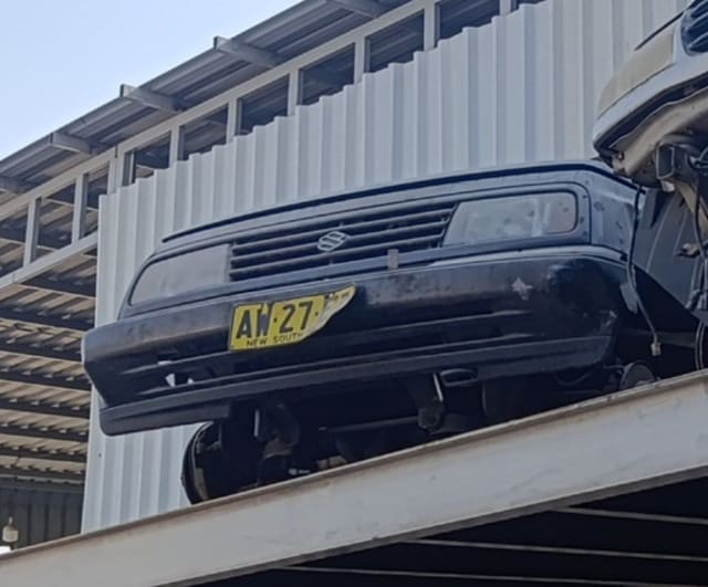Black Suzuki Vitara front halfcut on rack — bumper, grille and headlights, Sharjah market