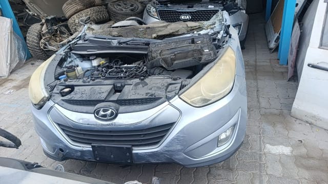 Silver Hyundai Tucson halfcut front: open engine bay, bumper, grille and headlights, Sharjah market