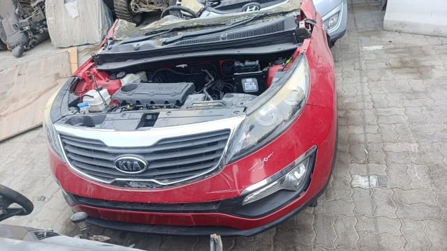 Red Kia Sportage front halfcut — bumper, grille, headlights and open engine bay, Sharjah market