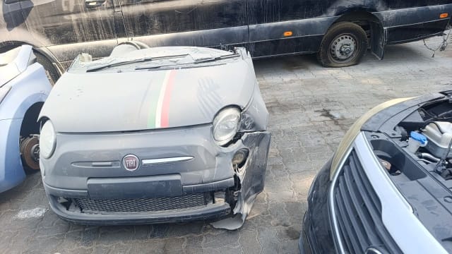 Grey Fiat 500 front cut with tricolour hood stripe, headlights and damaged bumper, Sharjah market