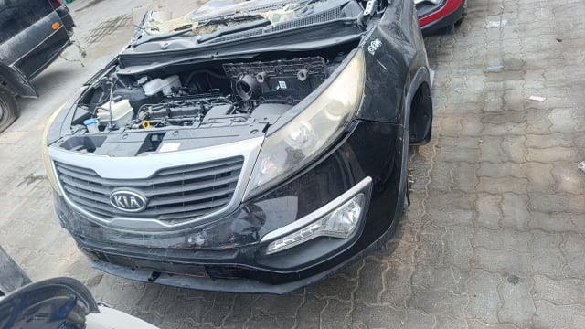 Black Kia Sportage front halfcut — open hood, engine, grille, headlights and bumper, Sharjah market