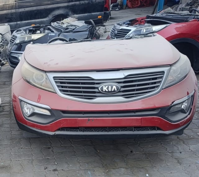 Red Kia Sportage front halfcut: hood, grille, headlights and bumper with fog lights, Sharjah market