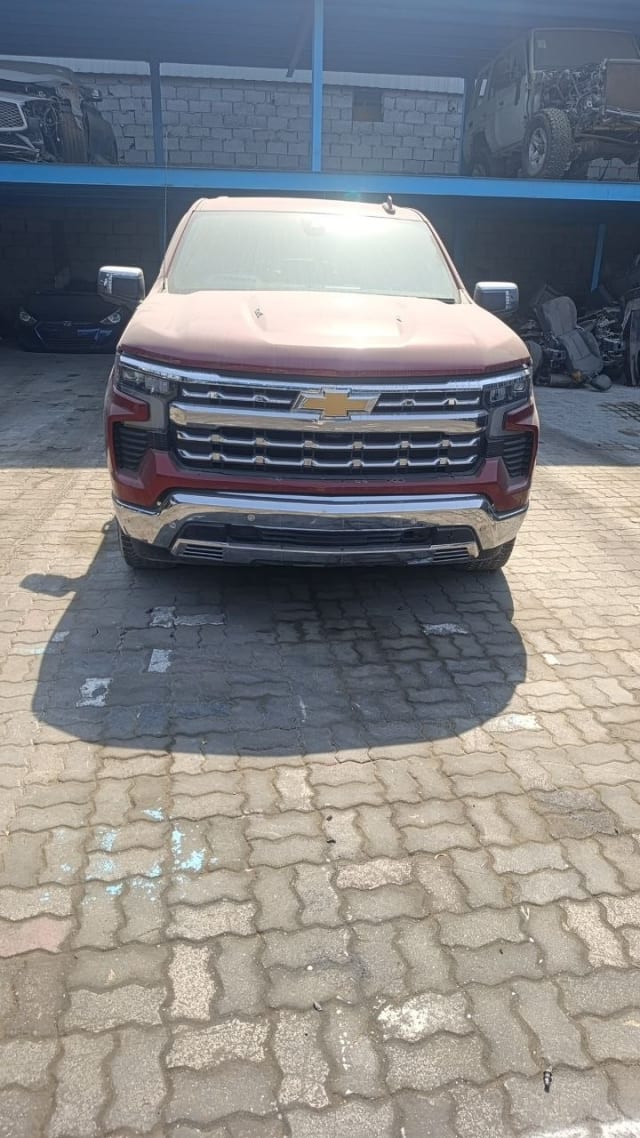 Dark red Chevrolet Silverado pickup front view — chrome grille, headlights, hood and bumper, Sharjah market