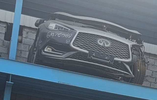 Dark grey Infiniti Q60 front halfcut, bumper, mesh grille and headlight on a rack, Sharjah market