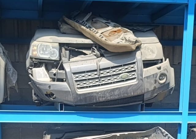 Grey Land Rover Freelander 2 front halfcut on a rack — hood, headlights, grille and bumper, Sharjah market