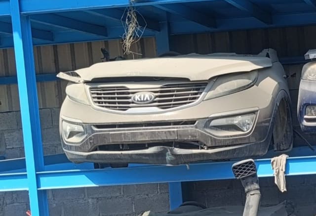 Beige Kia Sportage front halfcut on rack — hood, grille, bumper, headlights and fog lights, Sharjah market