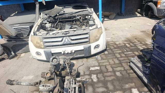 White Mitsubishi Pajero front halfcut, open engine bay, grille, bumper and headlights, Sharjah market
