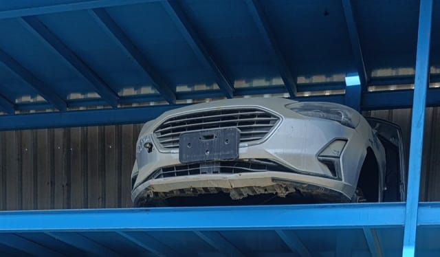 Silver Ford Focus front halfcut on a blue rack with bumper, grille and headlights, Sharjah market