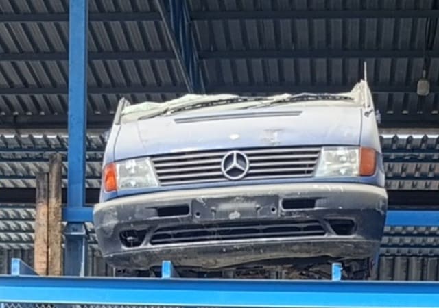 Light blue-grey Mercedes-Benz Vito van front halfcut: hood, grille, headlights and bumper on a rack, Sharjah market