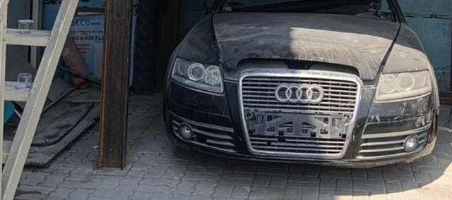Black Audi A6 sedan halfcut front: chrome grille, headlights, bumper and fog lights, Sharjah market