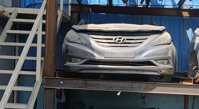 Silver Hyundai Sonata front halfcut with bumper, grille and headlights on a rack, Sharjah market