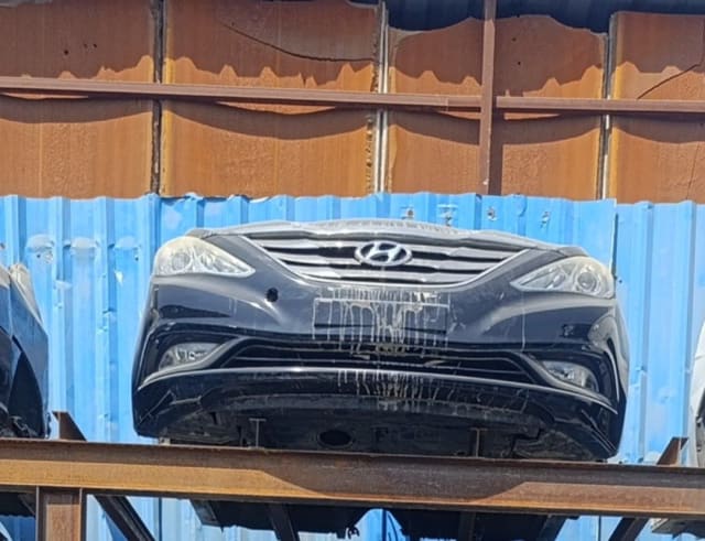 Black Hyundai Sonata 2011–2014 front halfcut with bumper, grille and headlights on a rack, Sharjah market