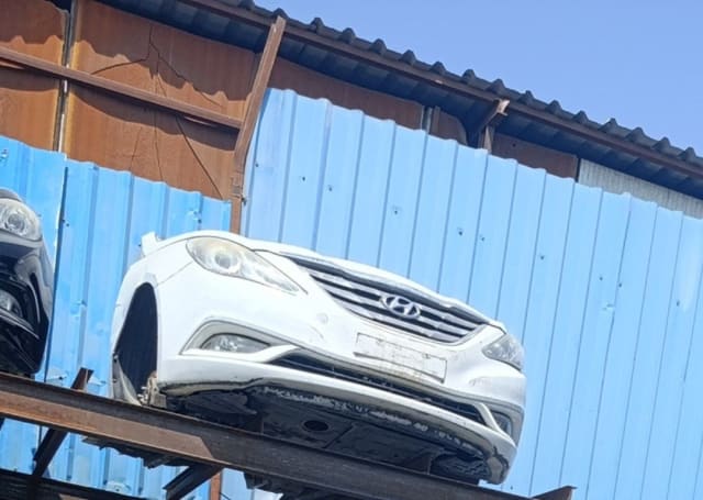 White Hyundai Sonata front halfcut with bumper, grille and headlights on a rack, Sharjah market