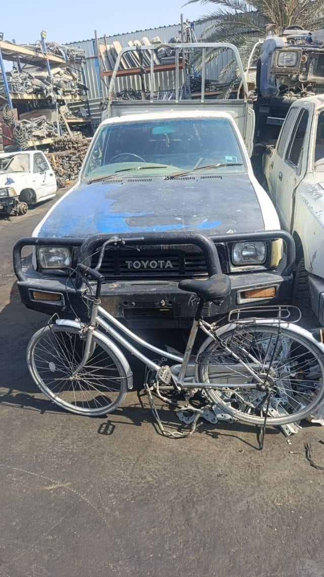 White Toyota Hilux pickup for parts, weathered hood, bull bar, grille and headlights, Sharjah market