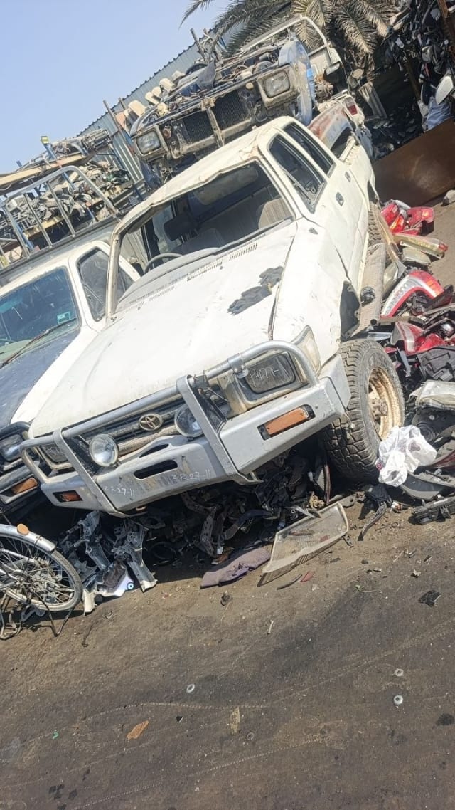 White Toyota Hilux pickup for parts — bull bar, grille, headlights and hood, Sharjah market
