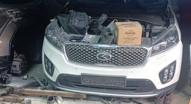 White Kia Sorento front halfcut: grille, headlights, fog lights and open engine bay, Sharjah market
