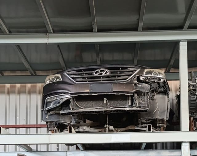 Dark brown Hyundai Sonata front halfcut on rack — grille, headlights, damaged bumper, Sharjah market