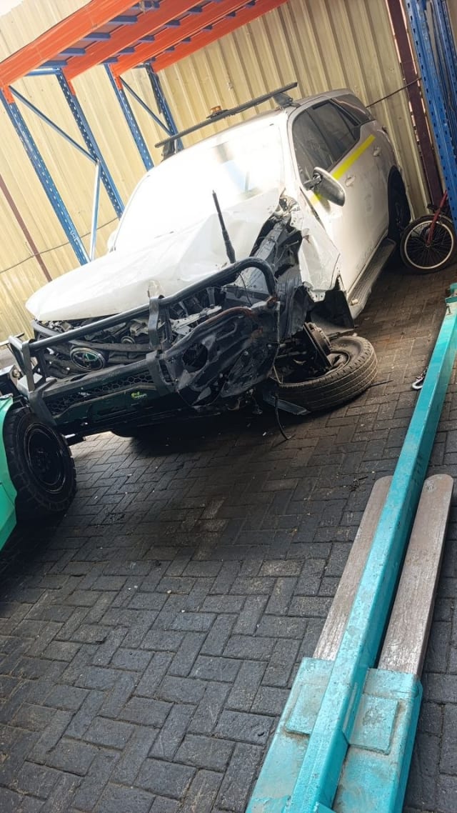 White Toyota Fortuner for parts — crushed front end, bull bar, hood and detached wheel, Sharjah market