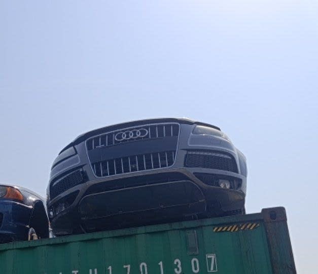Grey Audi Q7 front halfcut on a shipping container — chrome grille, bumper and headlights, Sharjah market