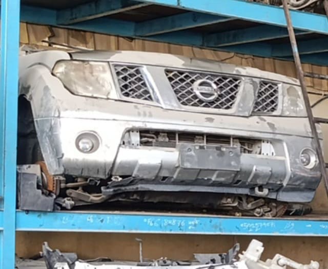 Silver Nissan Navara front halfcut on a rack: bumper, grille, headlights and hood, Sharjah market