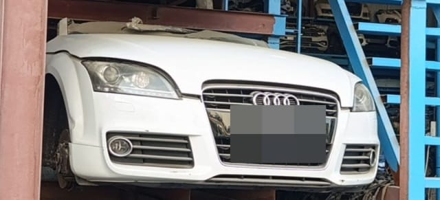 White Audi TT front halfcut with bumper, grille, headlights and hood on a rack, Sharjah market